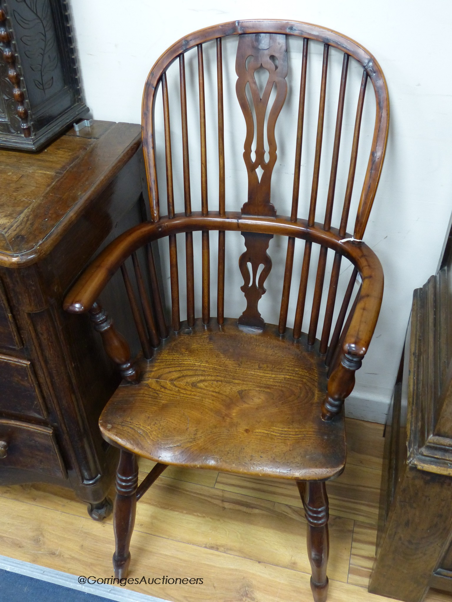 An early 19th century yew and elm Windsor armchair, with crinoline stretcher